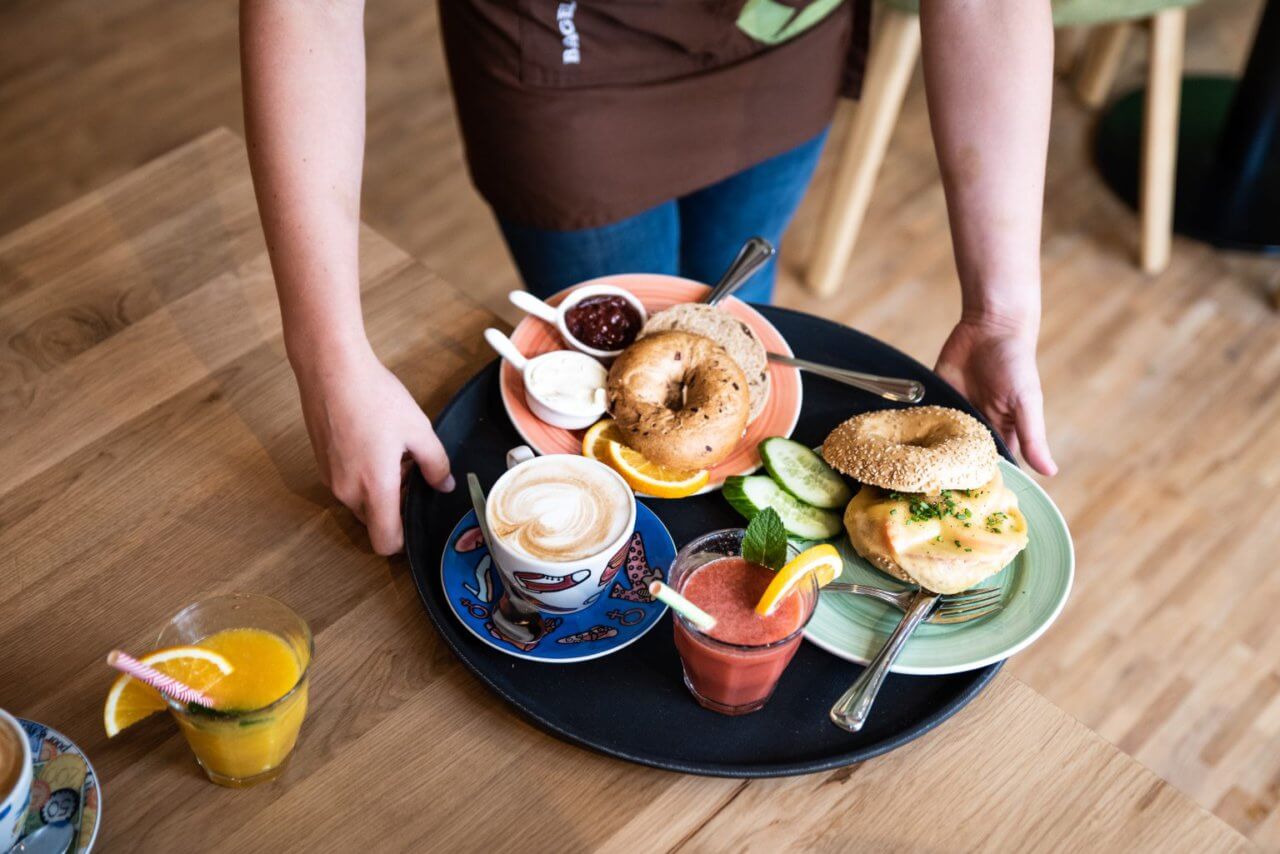 Een vol dienblad met koffie, sapjes en bagels