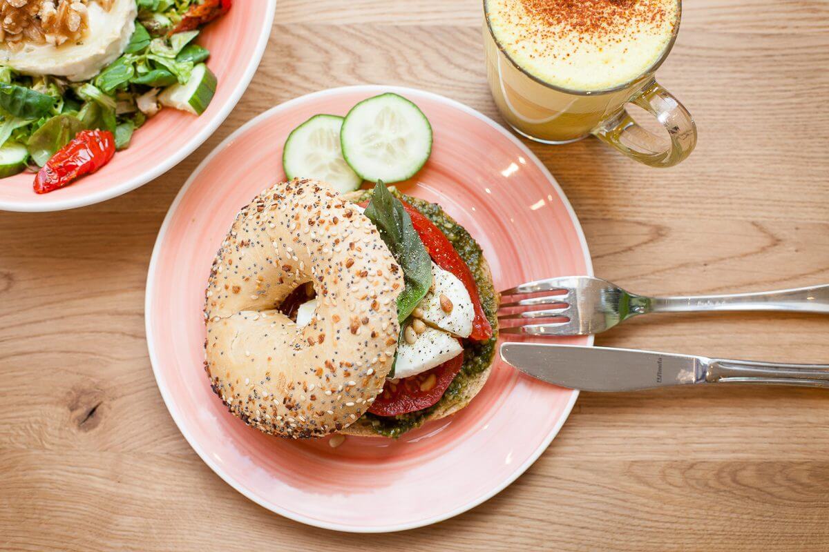 Een bagel gerecht met verse ingrediënten en koffie van boven gefotografeerd